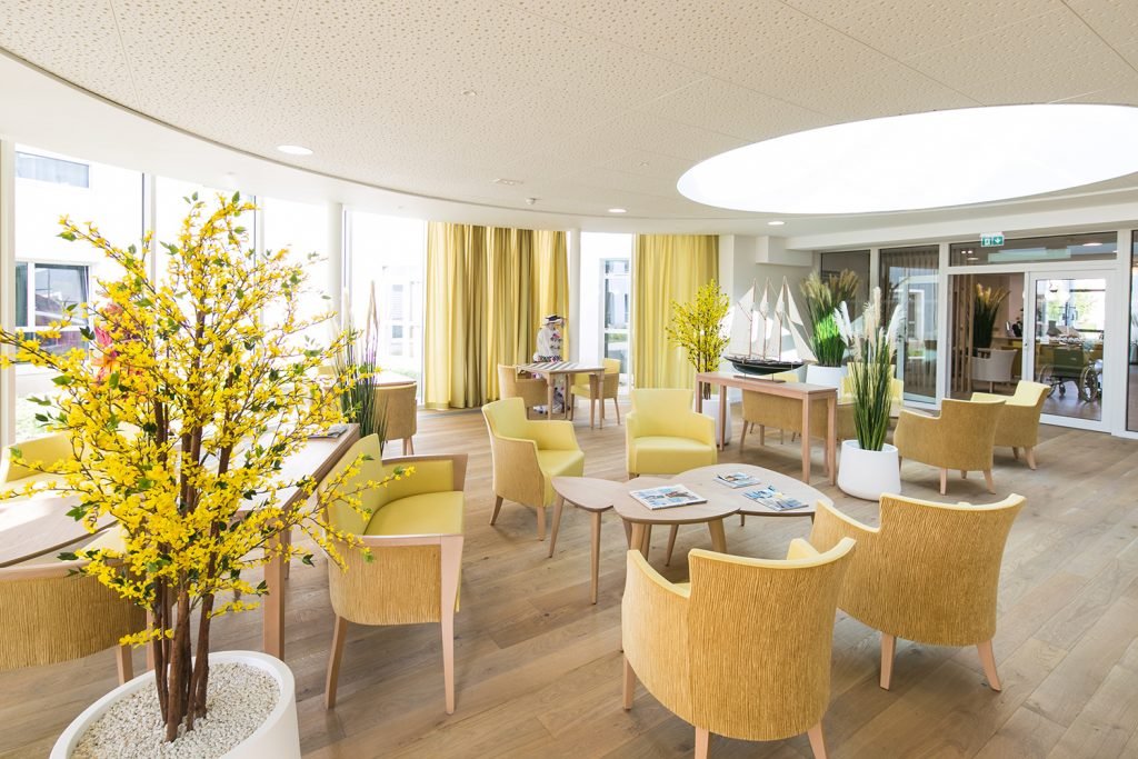 Grand salon avec ouverture vitrée sur le toit et baie vitrée ouverte sur le jardin