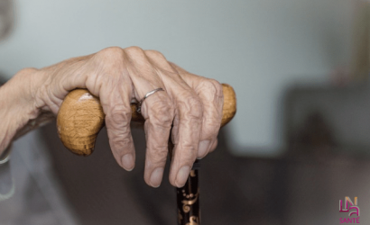 main personne âgée tenant une canne