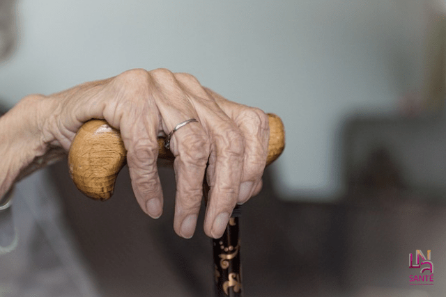 main personne âgée tenant une canne