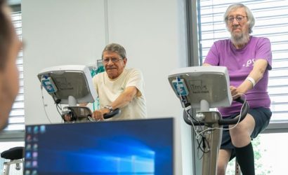 Soignant devant ordinateur surveille patients sur vélos de rééducation à l'effort