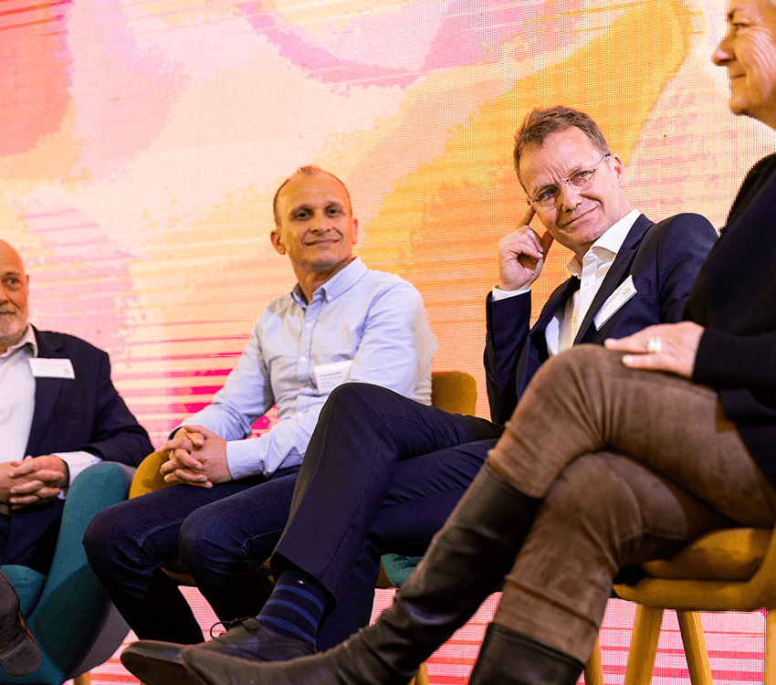 trois hommes et une femme assis autour d'une table ronde de discussion et d'échanges