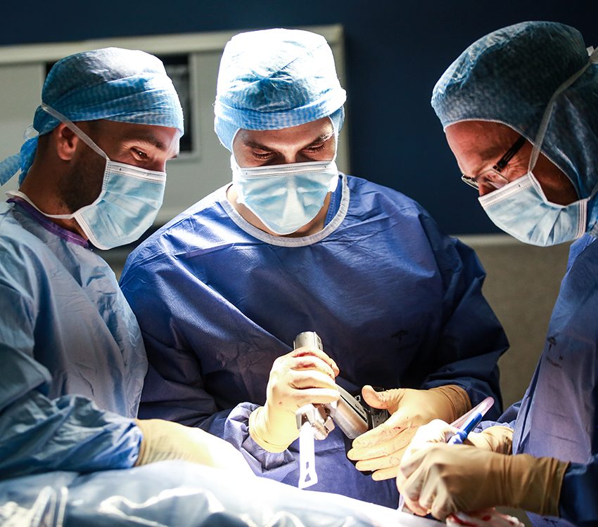 Médecins au bloc opératoire réalisant une chirurgie de la hanche